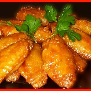 a plate of chicken wings with a garnish of parsley