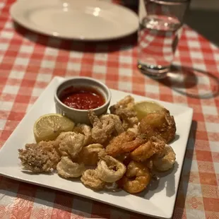 a plate of fried shrimp with a side of ketchup