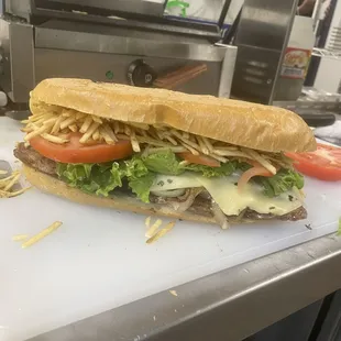 a sandwich with cheese, tomato, and lettuce