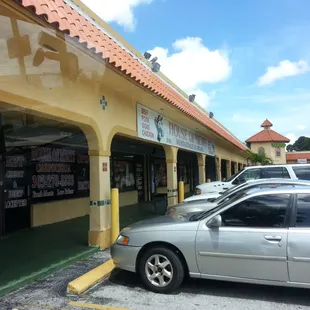 a silver car parked in front of a restaurant