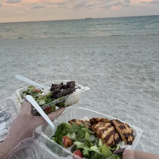 two people eating on the beach