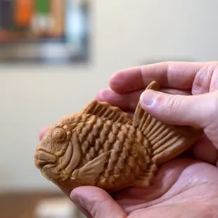 a hand holding a fish shaped biscuit