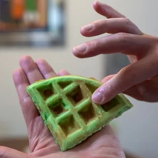 a hand holding a waffle