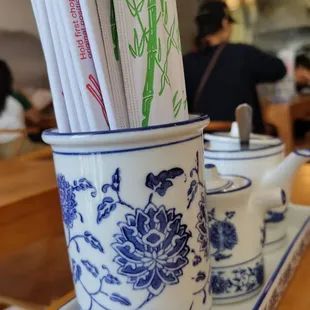 a blue and white cup with chopsticks in it