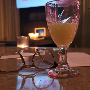 a pair of glasses on a table with a television in the background