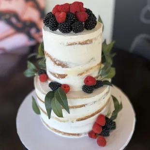 a three tiered cake with berries on top