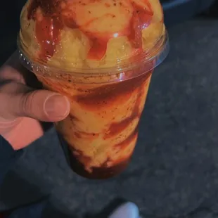 a person holding a cup of ice cream