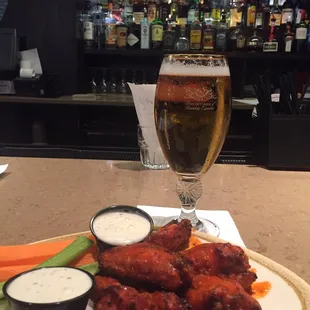 a plate of chicken wings and a glass of beer