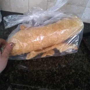 a hand holding a baguette