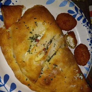 My Calzone after cutting off the corner - good flavor even without my Spinach.  On the side is their Jalapeno Poppers which we enjoyed.