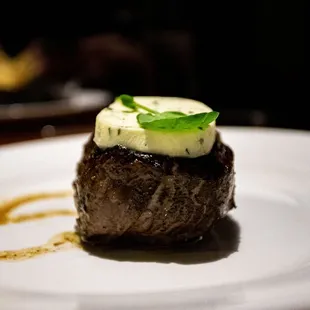 a piece of steak on a white plate