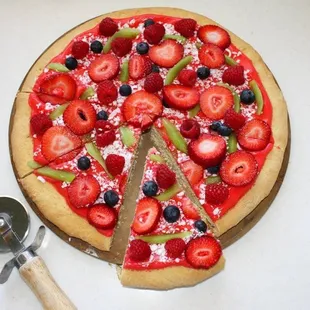 a pizza with strawberries and blueberries