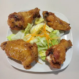 a plate of chicken wings and a salad