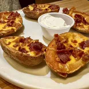 Potato Skins fried, topped with bacon, cheddar and chives served with sour cream