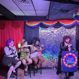 a group of people sitting on chairs in front of a stage