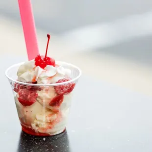 a cup of ice cream with a cherry on top