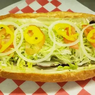 a hot dog with lettuce and tomatoes