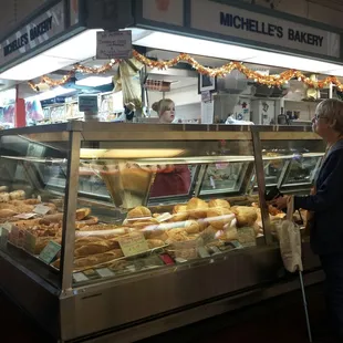 a woman standing in front of a bakery
