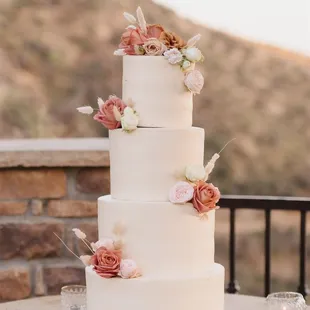 a three - tiered wedding cake with fresh flowers