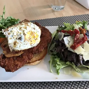 a plate of food with a fried egg and salad