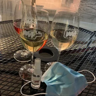 two glasses of wine and a face mask
