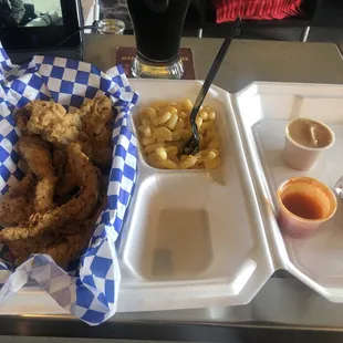 a tray of fried chicken, fries, and beer