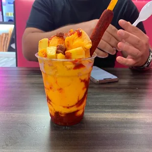a man sitting at a table with a cup of food