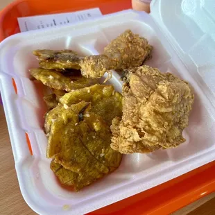 fried chicken and pickles in a styrofoam container