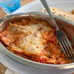 a fork in a bowl of lasagna