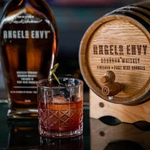 a glass of bourbon and a barrel of angel&apos;s envy