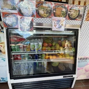 Display case filled with fruits and drinks
