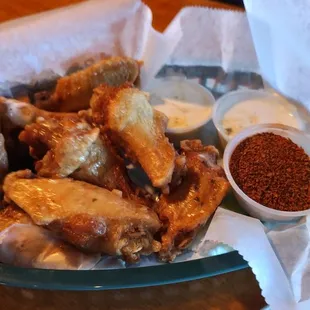 a basket of chicken wings with dipping sauce