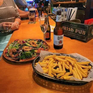 a plate of fries and a bottle of beer