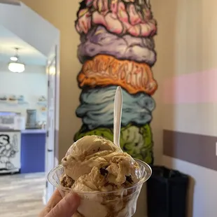 a hand holding a scoop of ice cream