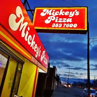 a neon sign for mickey's pizza