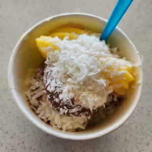 a bowl of frozen yogurt with a blue spoon