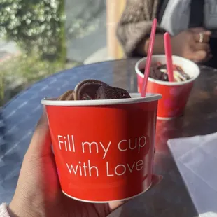a person holding a cup of yogurt