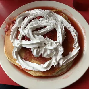 a plate of pancakes with whipped cream
