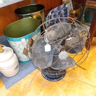 Vintage metal wastebaskets,antique fan, butter churn.