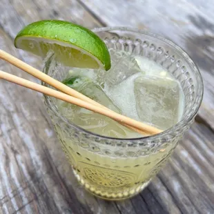 a cocktail with lime and chopsticks