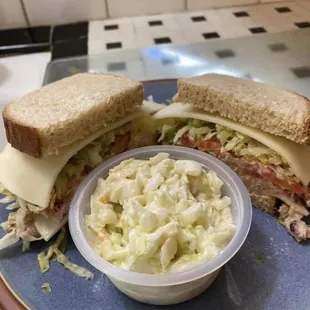 a plate with a sandwich and a bowl of coleslaw