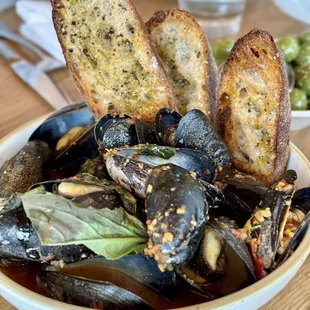 a bowl of mussels and bread