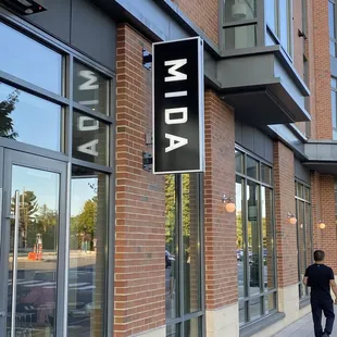 a man walking down a sidewalk in front of a building