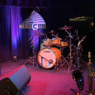 stage with drum, bass, and saxophone