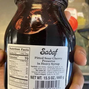 a hand holding a jar of sauce