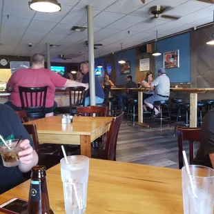 a man sitting at a table with a drink in his hand
