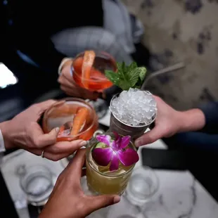 a group of people toasting with cocktails