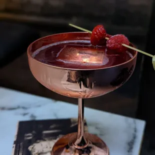a glass with a raspberry garnish