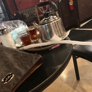 a tea kettle and a cup of tea on a table