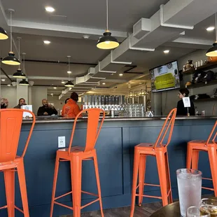a bar with orange chairs